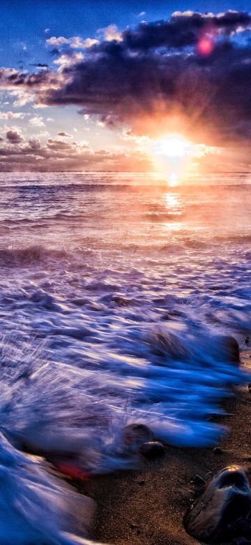 Image sea waves crashing on shore during sunset