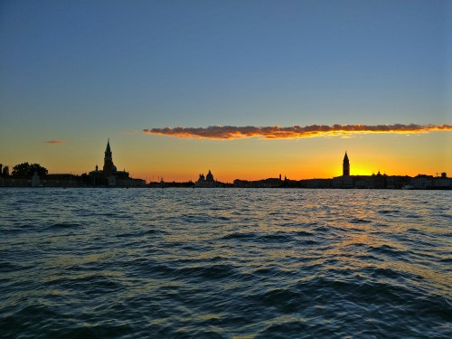 Image silhouette of people riding on boat during sunset