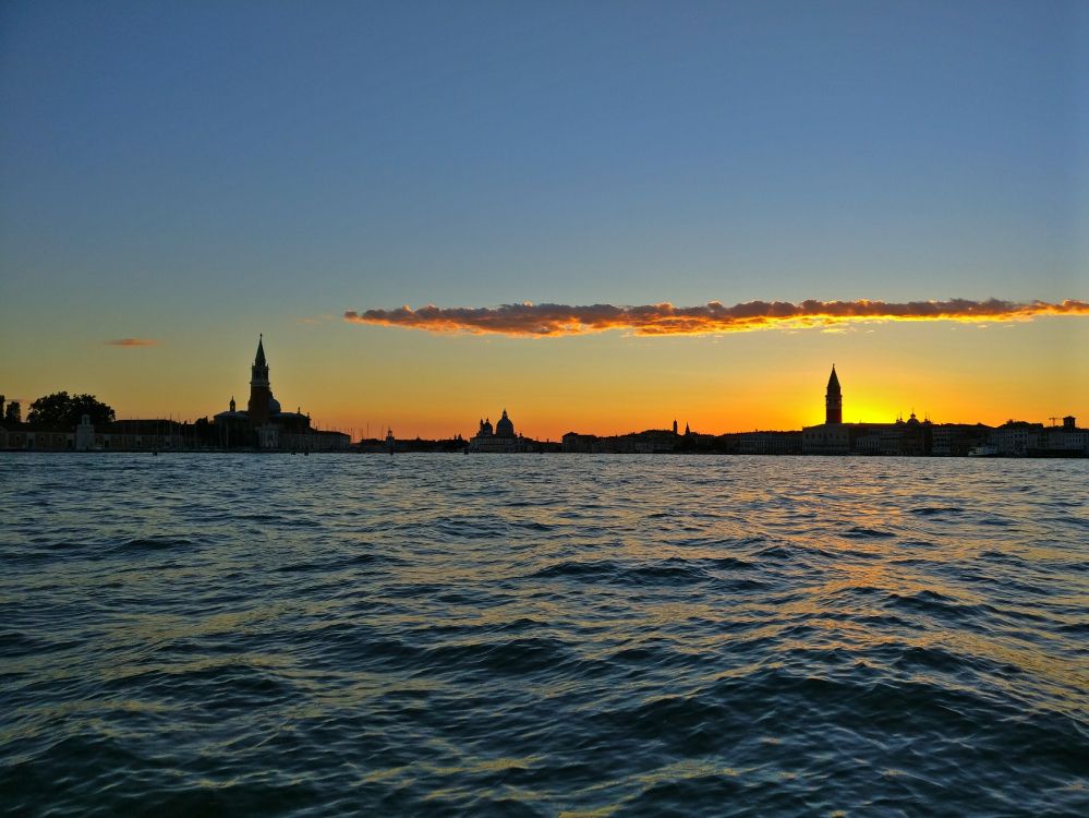 silhouette of people riding on boat during sunset