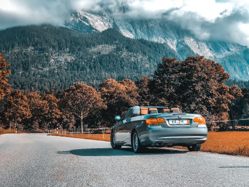 Image silver sedan on gray asphalt road during daytime