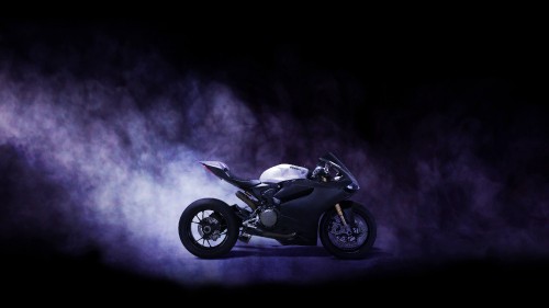 Image black and silver motorcycle in a dark room