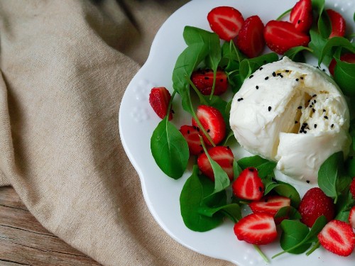 Image white ice cream with red rose petals on white ceramic plate