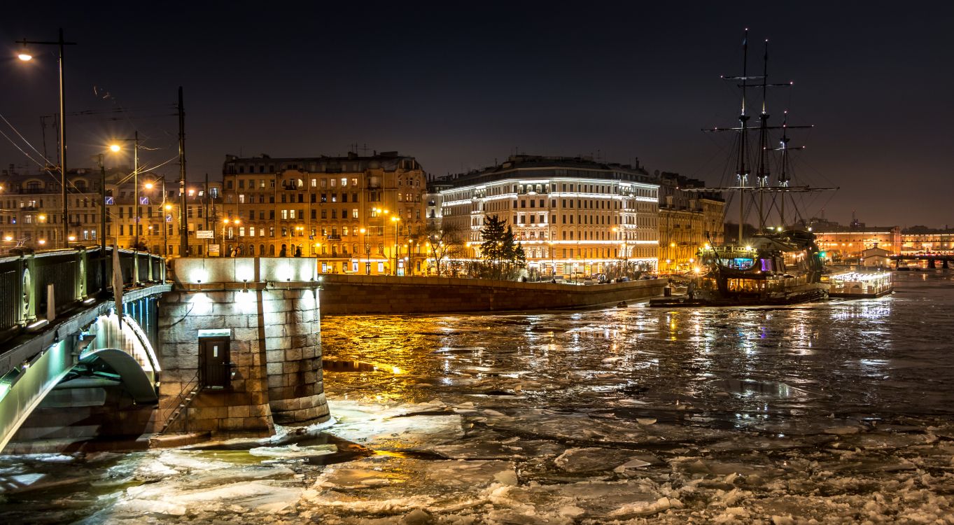 white concrete building near body of water during night time