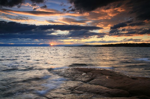 Image sea waves crashing on shore during sunset