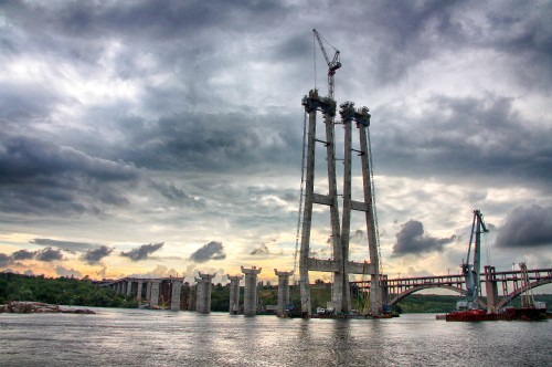 Image brown concrete building near body of water under cloudy sky during daytime