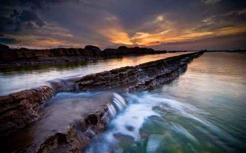 Image body of water under cloudy sky during daytime
