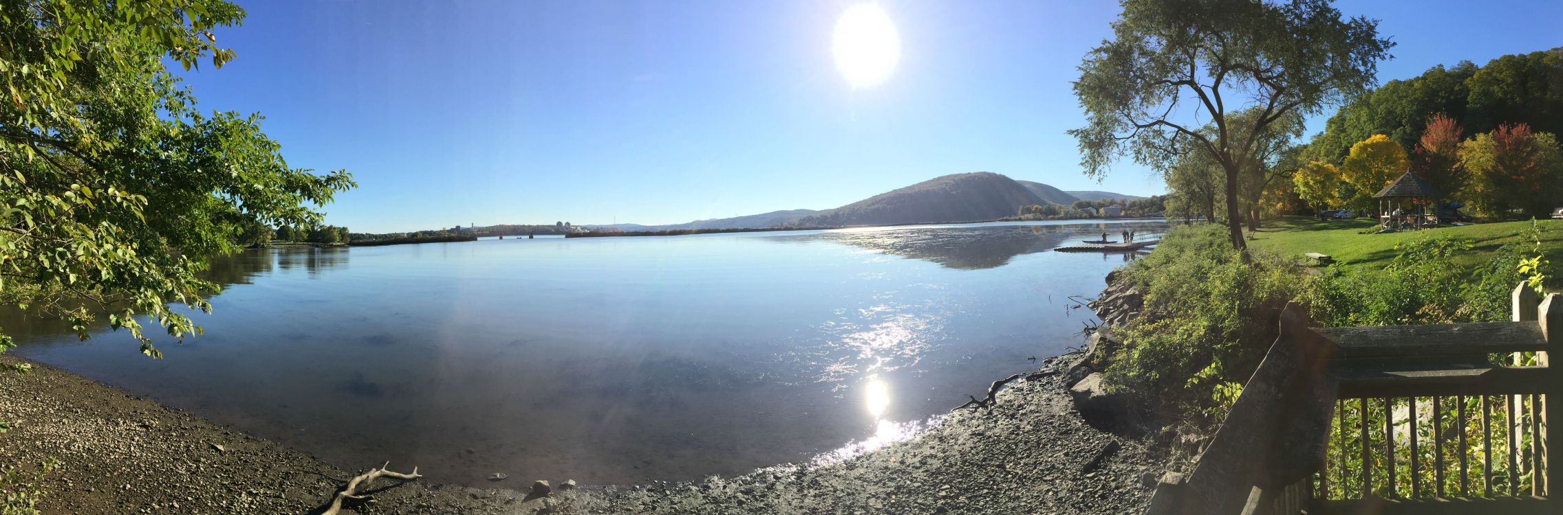 body of water near mountain under blue sky during daytime