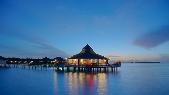 Image brown wooden gazebo on body of water during night time