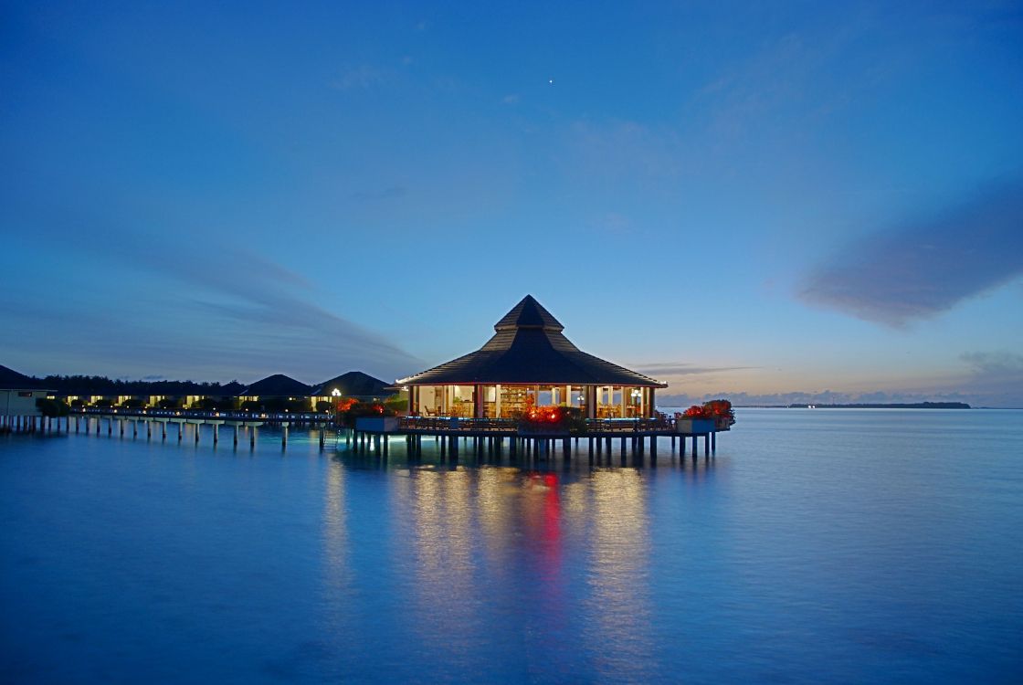 brown wooden gazebo on body of water during night time