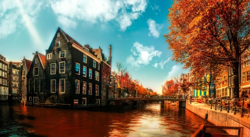 Image brown and black concrete building near body of water under blue sky during daytime