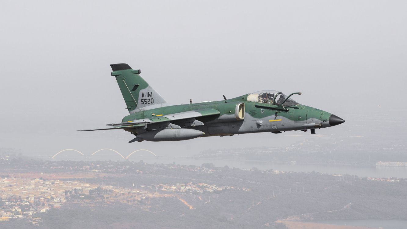 green and black jet plane flying over the white clouds during daytime