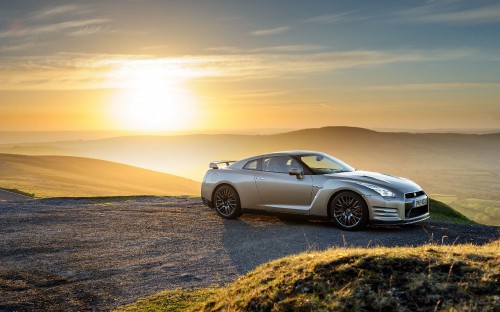 Image silver sedan on brown sand during sunset