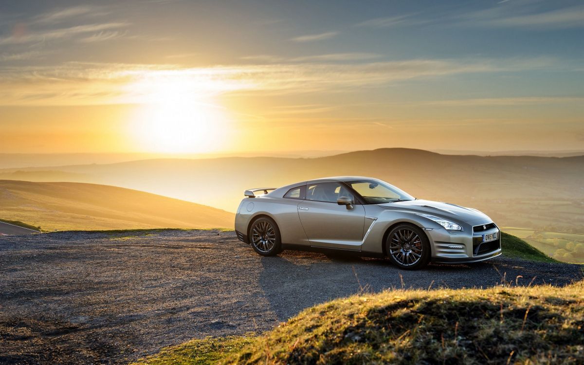 silver sedan on brown sand during sunset