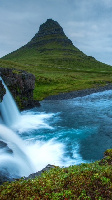 Image green mountain near waterfalls under cloudy sky during daytime