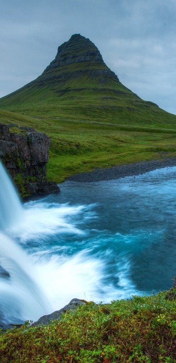 Image green mountain near waterfalls under cloudy sky during daytime