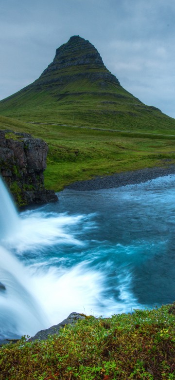 Image green mountain near waterfalls under cloudy sky during daytime