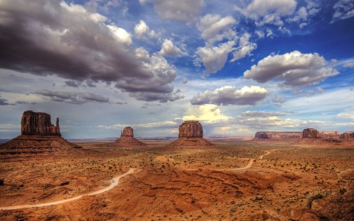 Image brown sand under white clouds and blue sky during daytime