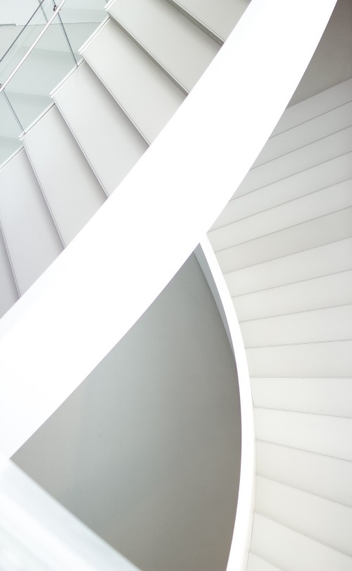 Image white concrete spiral staircase during daytime