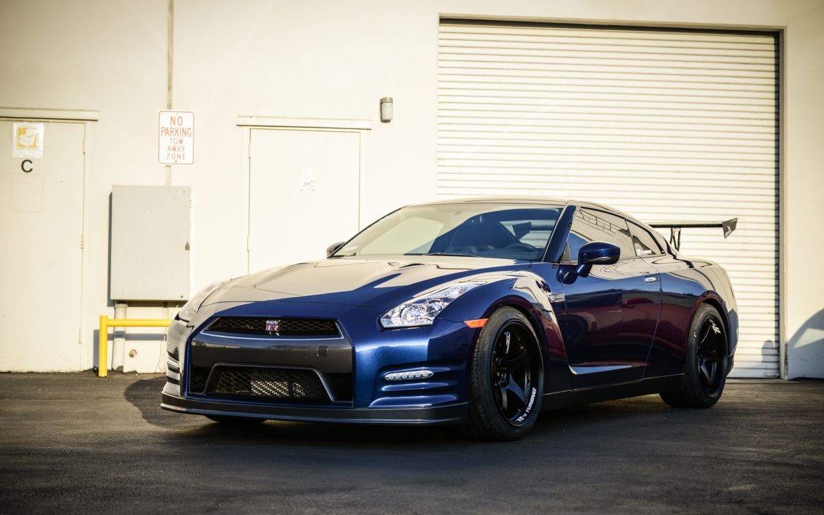 Blaues Bmw m 3 Coupe in Der Nähe Von Weißer Rolltür Geparkt. Wallpaper in 2048x1280 Resolution