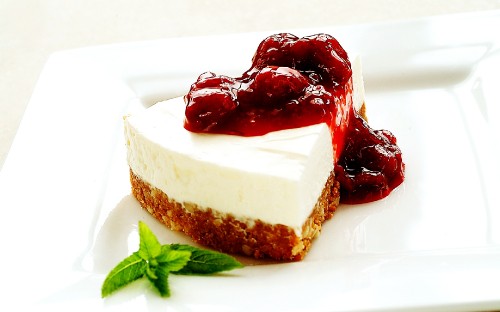 Image brown and white cake with red rose on white ceramic plate