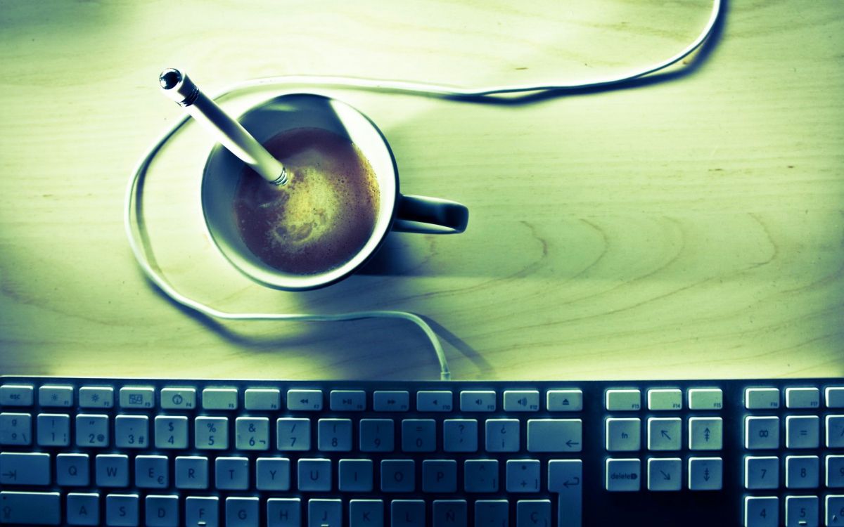 white ceramic mug on white ceramic saucer beside black computer keyboard