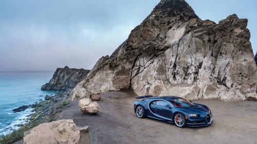 Image blue coupe on gray rocky mountain during daytime