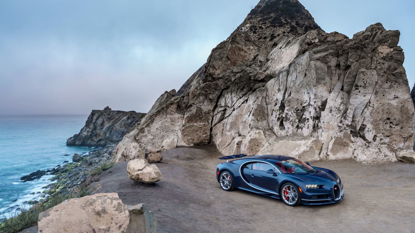 blue coupe on gray rocky mountain during daytime