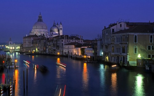 Image white and brown concrete building near body of water during night time