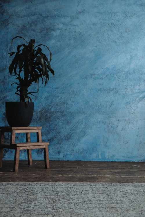 Image brown wooden table beside blue painted wall