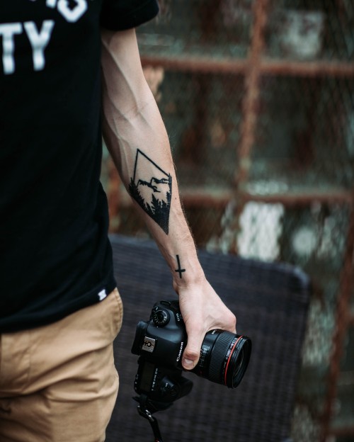 Image man in black tank top holding black dslr camera