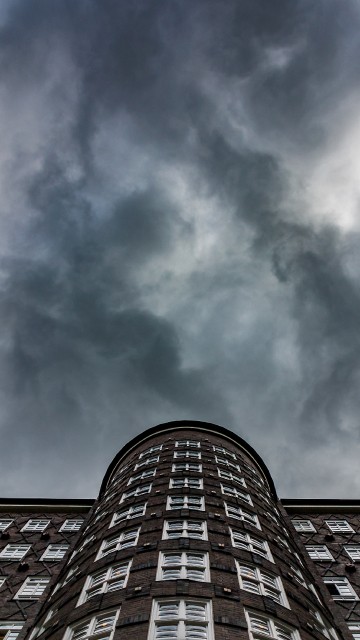 Image brown brick building under white clouds and blue sky during daytime