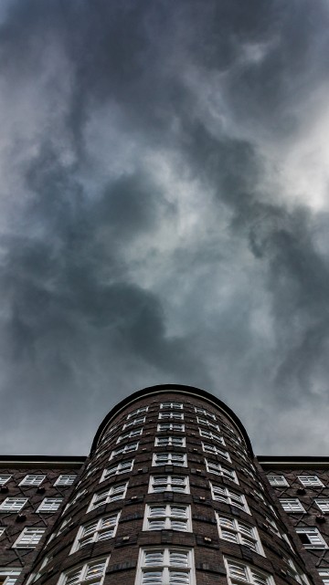 Image brown brick building under white clouds and blue sky during daytime