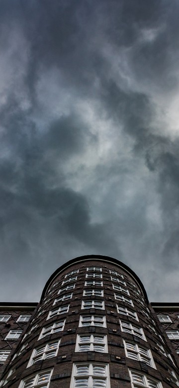 Image brown brick building under white clouds and blue sky during daytime