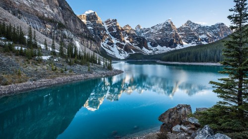 Image lake surrounded by trees and mountains during daytime