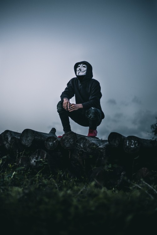Image man in black jacket sitting on rock