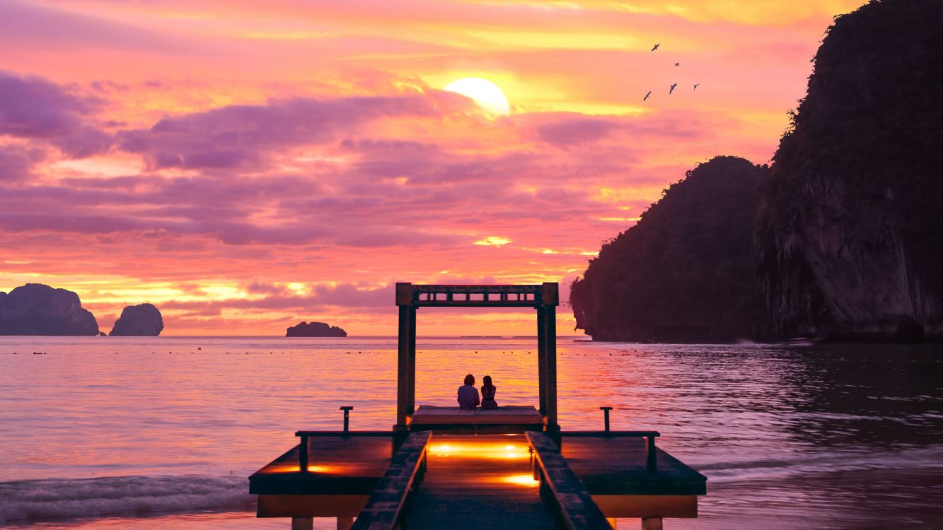 brown wooden dock on body of water during sunset
