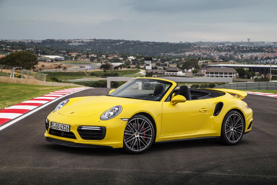 Porsche 911 Jaune Sur Une Colline Avec Vue Sur Les Bâtiments de la Ville Pendant la Journée. Wallpaper in 3600x2400 Resolution